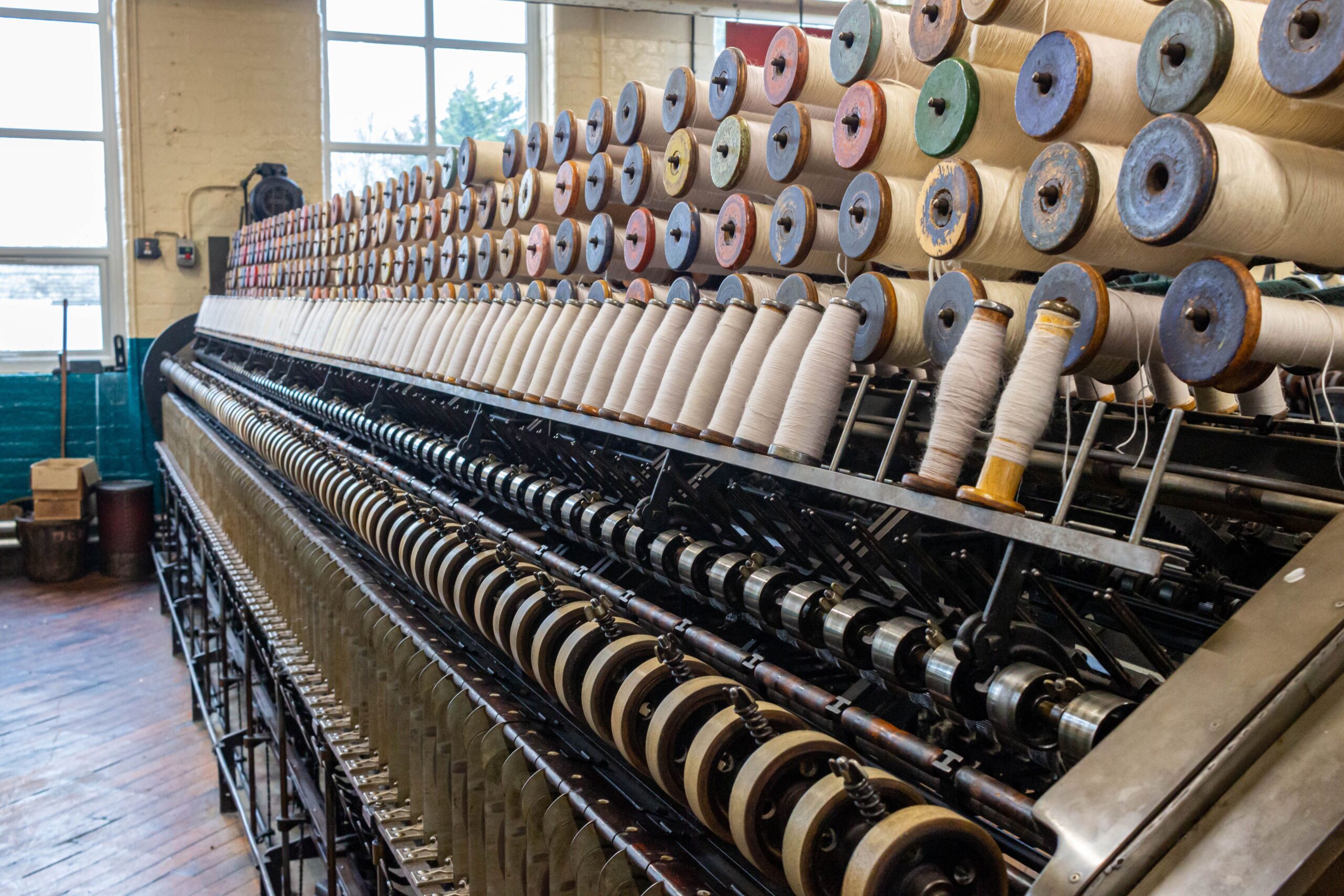 a big long machine on a hard wood floor of a large factory