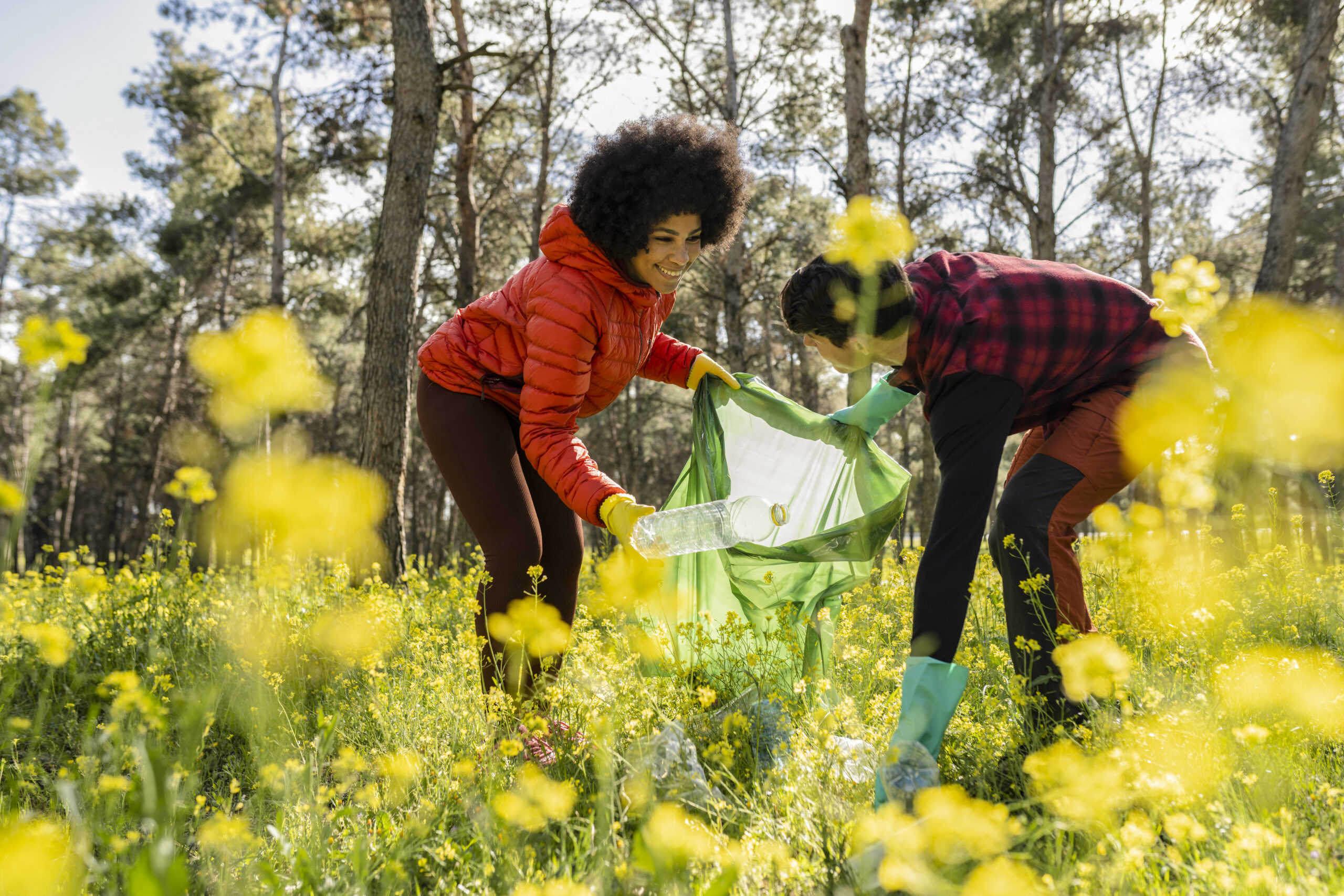 Multiracial couple recycling and collecting garbage in the fores